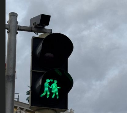 Pedestrian traffic light under cloudy sky